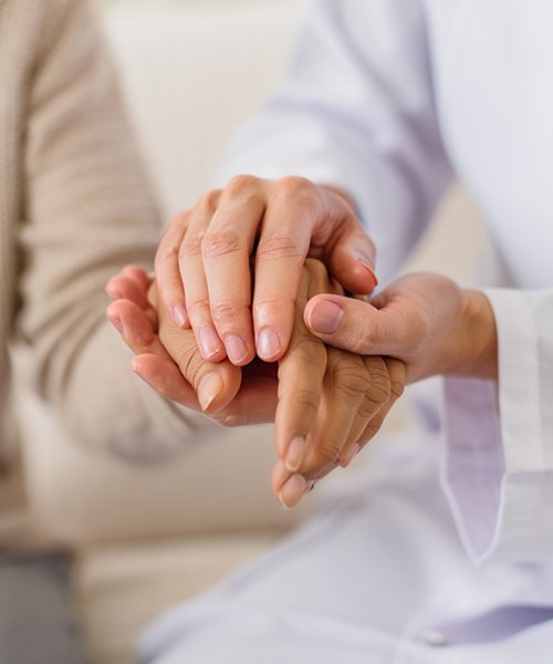 Врач держит пациента за руку